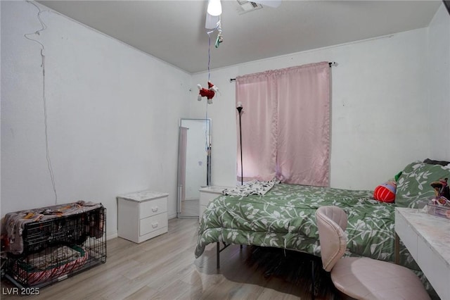 bedroom with light wood finished floors and visible vents