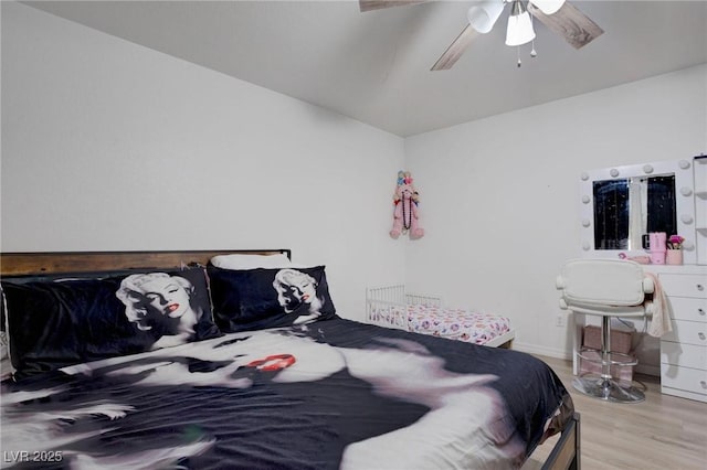 bedroom featuring a ceiling fan, lofted ceiling, and light wood-style flooring