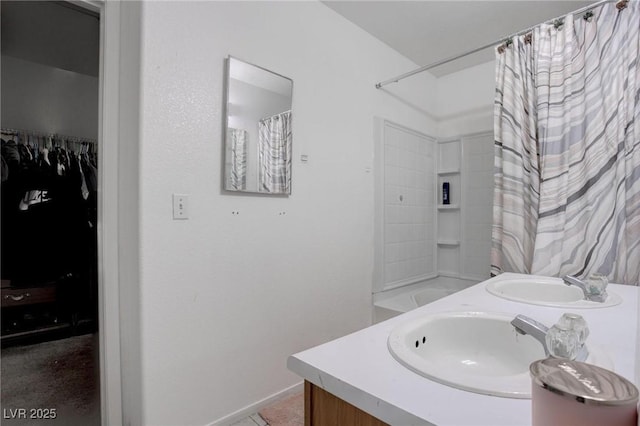 bathroom featuring double vanity, shower / tub combo, a spacious closet, and a sink