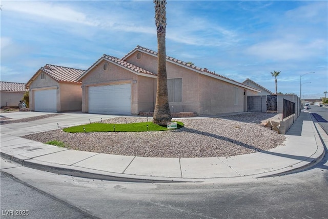 view of front of house featuring a garage, concrete driveway, and stucco siding