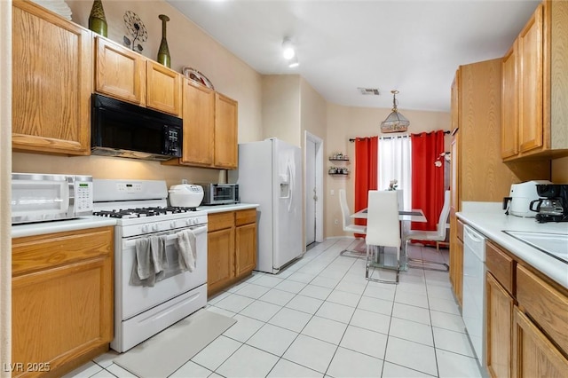 kitchen featuring white appliances, light tile patterned floors, visible vents, lofted ceiling, and light countertops