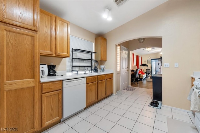 kitchen with arched walkways, lofted ceiling, white dishwasher, visible vents, and light countertops