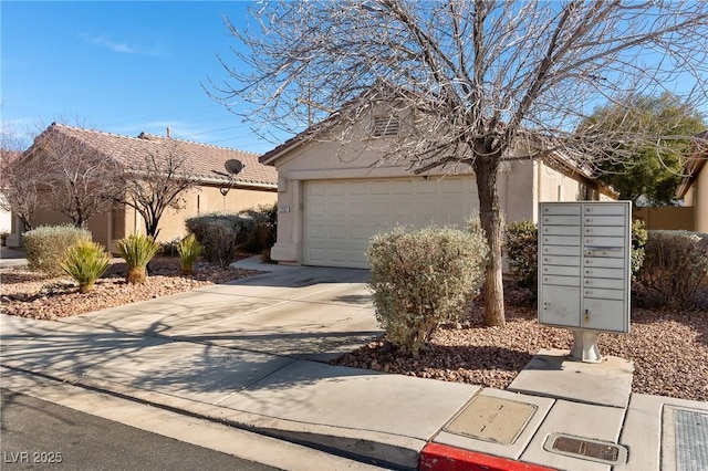 exterior space featuring a tile roof, stucco siding, concrete driveway, an attached garage, and mail area