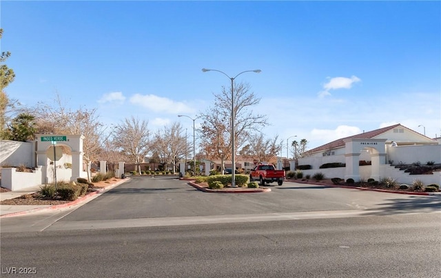 view of road featuring curbs, street lighting, sidewalks, and a residential view