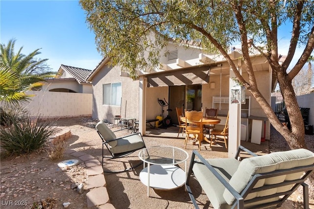 back of house with stucco siding, a patio area, fence, and a pergola