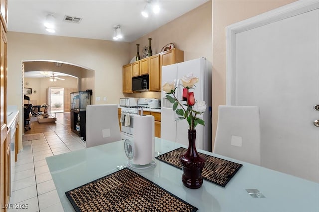 kitchen with arched walkways, visible vents, light brown cabinetry, a ceiling fan, and white appliances