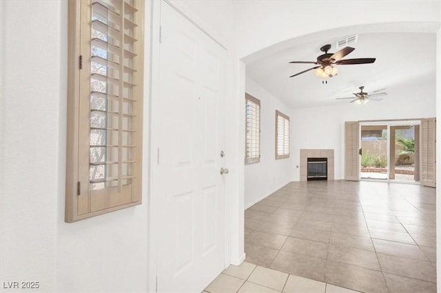2137 Hidden Ranch Ter, Henderson, NV 89052 - unfurnished living room with light tile patterned floors, ceiling fan, and a tiled fireplace