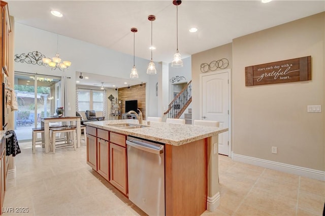 kitchen featuring a large fireplace, dishwasher, decorative light fixtures, a kitchen island with sink, and a sink