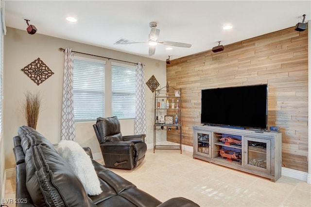 living area with ceiling fan, recessed lighting, an accent wall, visible vents, and baseboards