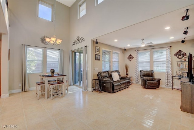 living area featuring ceiling fan with notable chandelier, recessed lighting, and baseboards