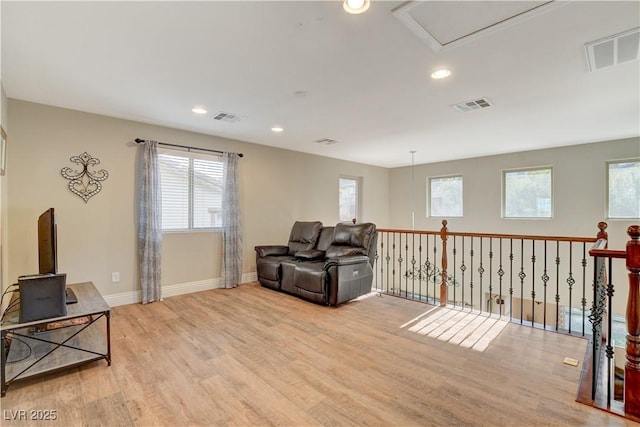 sitting room featuring light wood finished floors, visible vents, and a healthy amount of sunlight