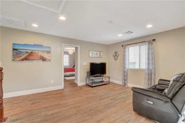 living area with recessed lighting, visible vents, light wood-style flooring, and baseboards