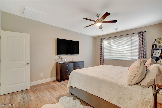 bedroom featuring light wood-type flooring, visible vents, ceiling fan, and baseboards