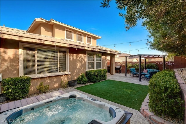 back of property featuring a yard, hot tub deck surround, stucco siding, and a pergola