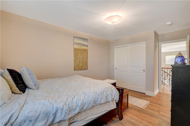 bedroom with a closet, baseboards, and wood finished floors