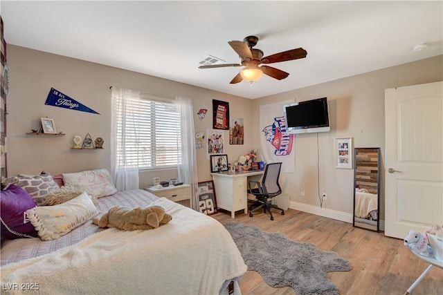 bedroom with ceiling fan, light wood finished floors, visible vents, and baseboards