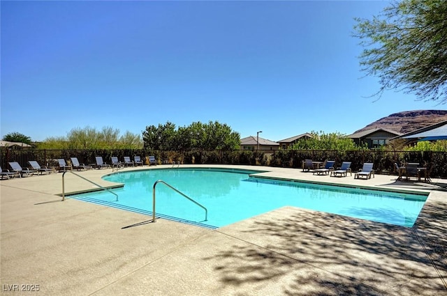 pool with a patio area and fence