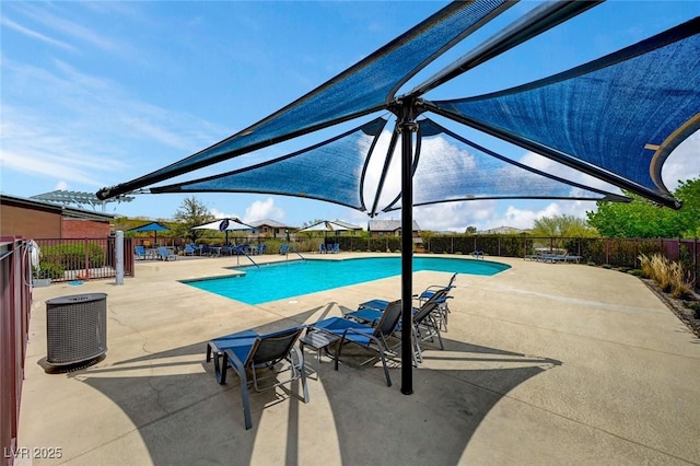 community pool with fence and a patio