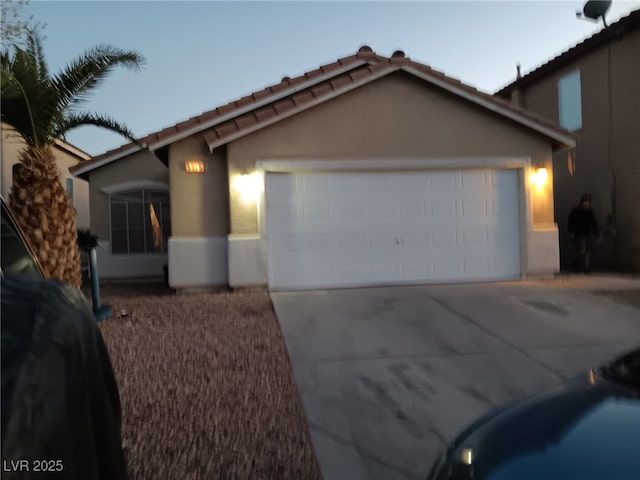 view of front facade with concrete driveway, an attached garage, and stucco siding