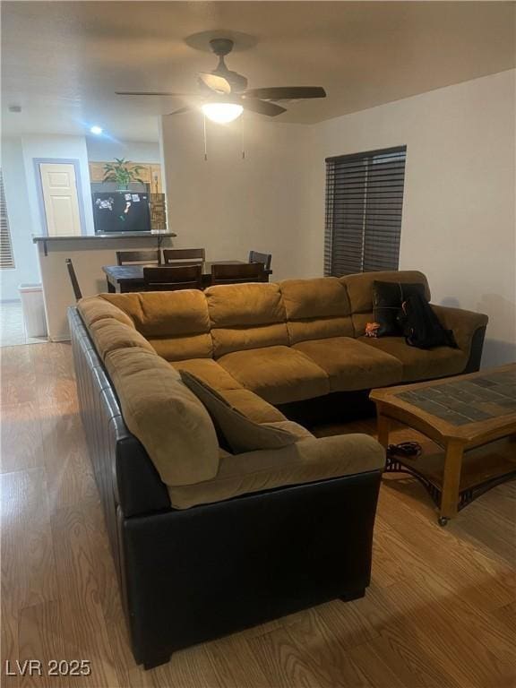 living room with light wood-style flooring and ceiling fan