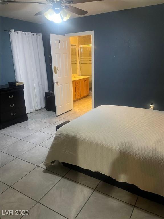 bedroom featuring a ceiling fan, light tile patterned flooring, and ensuite bathroom