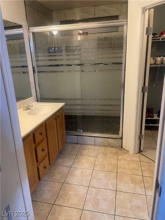 full bathroom featuring a stall shower, vanity, and tile patterned floors