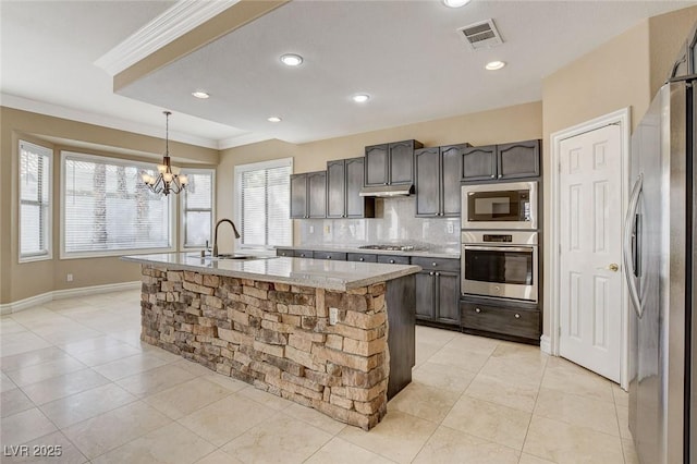 kitchen with a center island with sink, stainless steel appliances, visible vents, dark brown cabinetry, and a sink