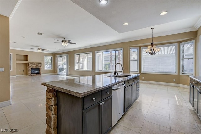 kitchen featuring dark brown cabinetry, a kitchen island with sink, crown molding, stainless steel dishwasher, and a sink