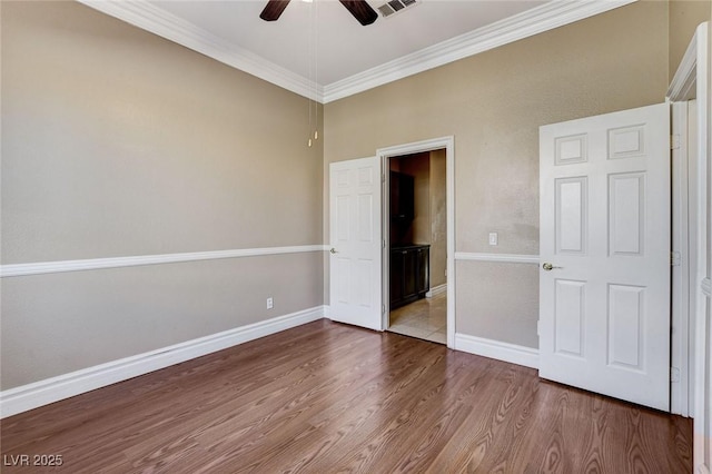 unfurnished bedroom with ceiling fan, ornamental molding, wood finished floors, and baseboards