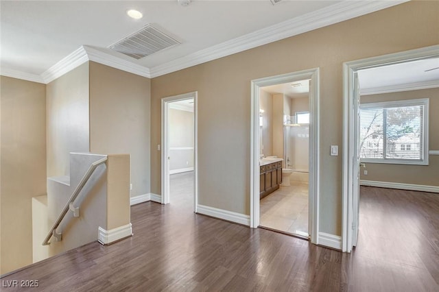 interior space featuring crown molding, visible vents, an upstairs landing, wood finished floors, and baseboards