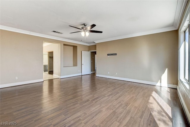 empty room featuring ceiling fan, wood finished floors, visible vents, baseboards, and crown molding