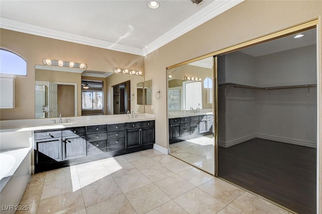 bathroom featuring double vanity, crown molding, and a sink