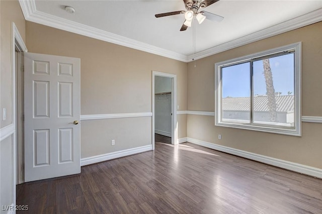 spare room with ceiling fan, baseboards, dark wood finished floors, and crown molding