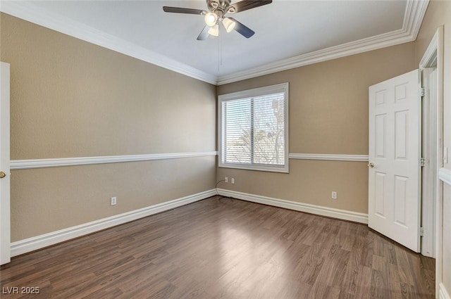 spare room with ornamental molding, dark wood-style flooring, baseboards, and a ceiling fan
