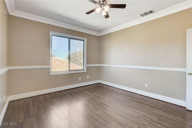 spare room with baseboards, visible vents, a ceiling fan, wood finished floors, and crown molding