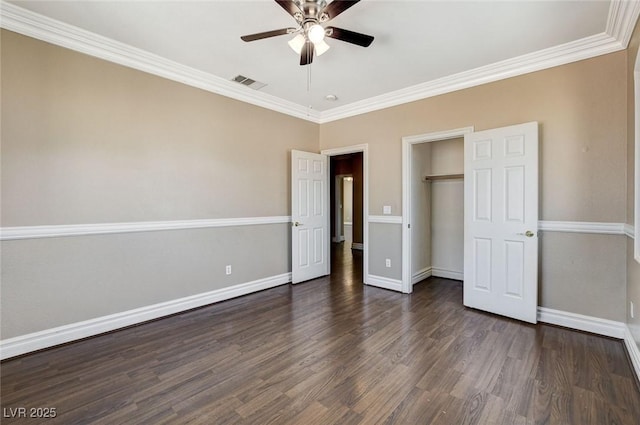 unfurnished bedroom with dark wood-style flooring, visible vents, baseboards, ornamental molding, and a closet