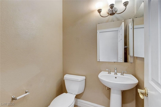 bathroom with baseboards and toilet
