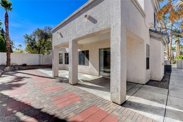 rear view of house featuring a fenced backyard, a patio, and stucco siding