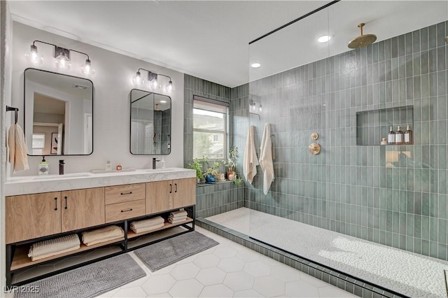 bathroom featuring double vanity, tile patterned flooring, a walk in shower, and a sink