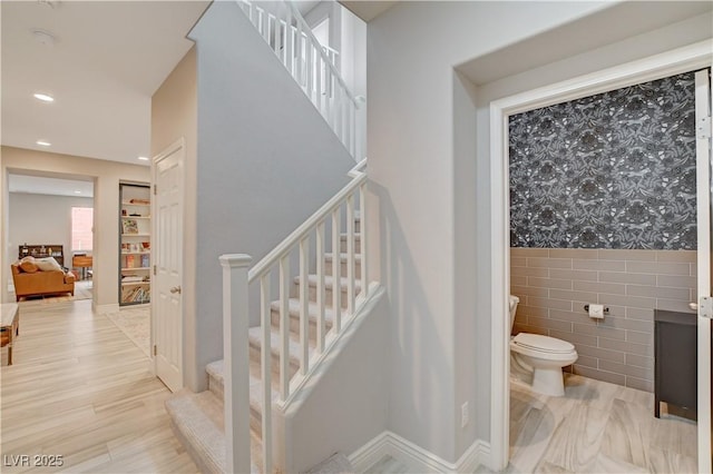 interior space with recessed lighting, tile walls, toilet, and wood finished floors