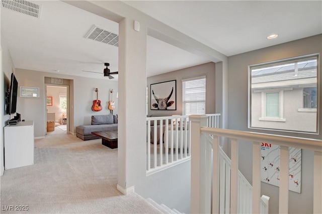 corridor featuring recessed lighting, light colored carpet, visible vents, and an upstairs landing