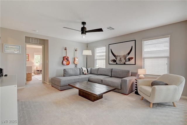 living area featuring light colored carpet, visible vents, ceiling fan, and baseboards