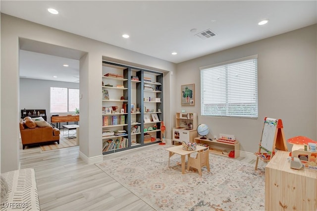 playroom with light wood-style floors, visible vents, and recessed lighting