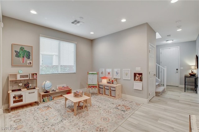 recreation room featuring light wood-type flooring, visible vents, baseboards, and recessed lighting