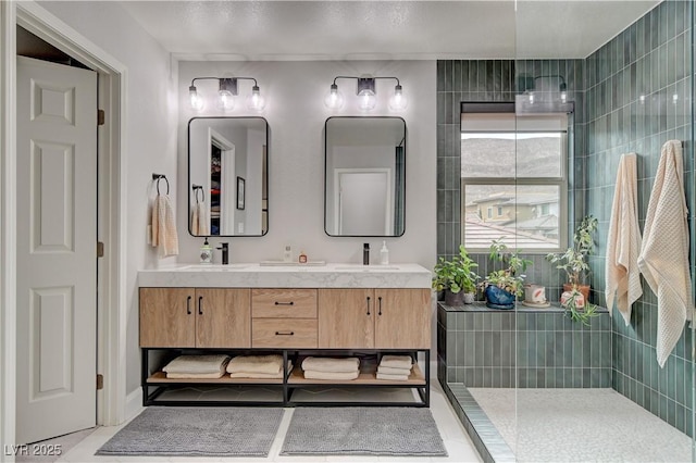 bathroom featuring double vanity, walk in shower, and a sink