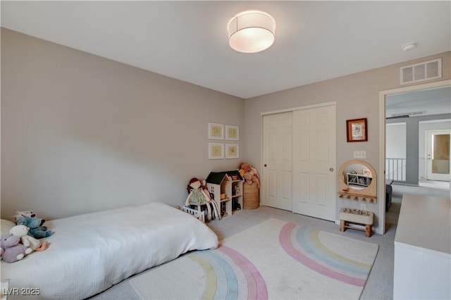 bedroom featuring a closet, visible vents, and light colored carpet