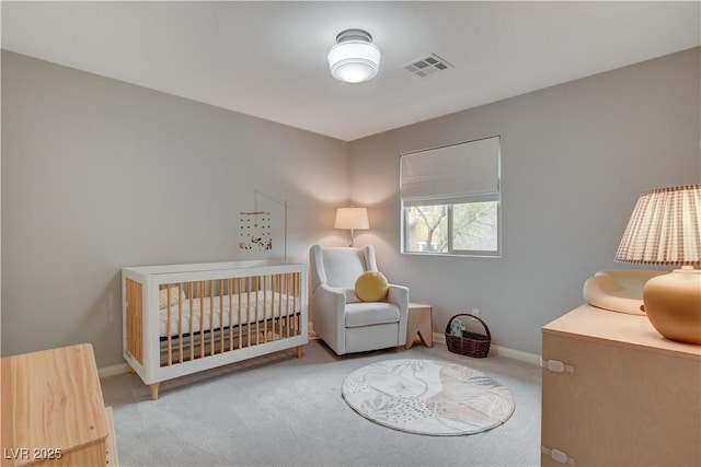 bedroom featuring light colored carpet, a nursery area, visible vents, and baseboards