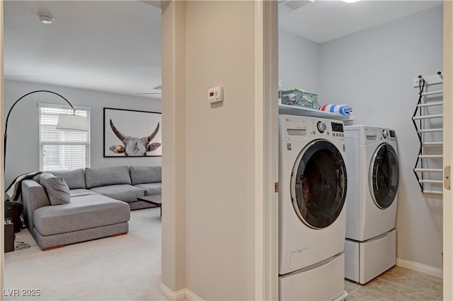 laundry area with laundry area, baseboards, washing machine and clothes dryer, and light tile patterned floors