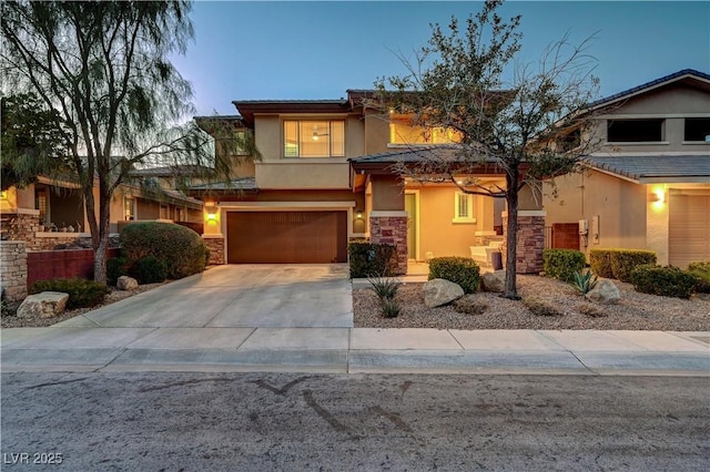 view of front of house featuring a garage, stone siding, concrete driveway, and stucco siding