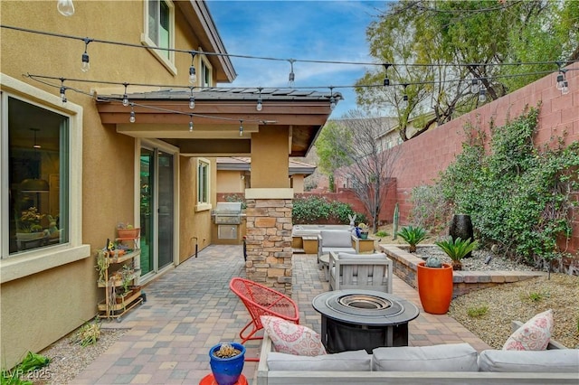 view of patio with an outdoor living space with a fire pit, a fenced backyard, and area for grilling